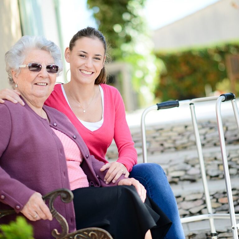 Cheerful,old,woman,in,wheelchair,with,her,young,granddaughter,outdoor